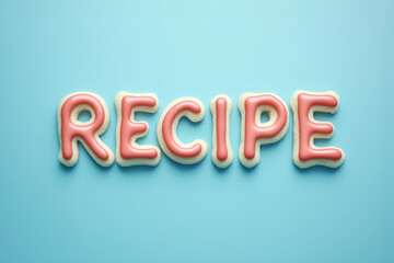 RECIPE decorated 3d type text made from sugar cookie with pink frosting isolated on a plain blue color studio background