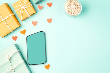 A vibrant scene featuring wrapped gifts, a smartphone, and decorative hearts against a pastel blue background, suggesting celebration and connection.