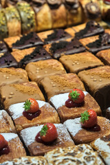 Square pastries dusted with powdered sugar, topped with fresh strawberries and jam, with golden, flaky layers and gourmet detailing.