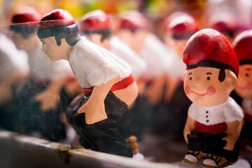 Traditional catalan statues called "caganers" are seen in a stall at a Christmas market at night. Concept of catalan ans spanish culture