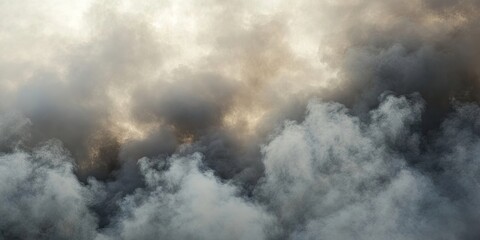 Fototapeta premium Dense dark gray smoke clouds with lighter gray and beige tones creating a dramatic sky obscuring sunlight in a turbulent atmosphere.