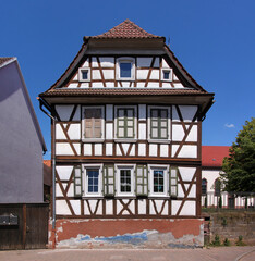 A decaying half-timbered wooden residential house with its half-hipped gable in the old village of Steinweiler, Pfalz region in Germany