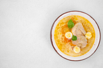 Quail broth or soup in a bowl on a white background top view. copy space