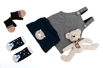 Knitted romper,sweater,jumper,socks,mittens,teddy bear.Fashion baby childs clothes outfit in pastel colors on white background. Flat lay, top view.