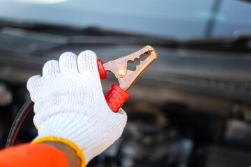 Action of a technician hand is using an emergency clamping kit to clamp on positive polar for...