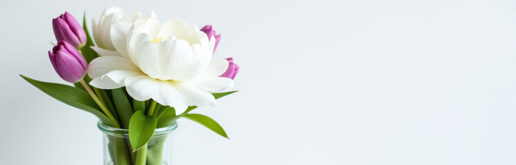 Fototapeta premium A Delicate Bouquet Of White Peonies And Purple Tulips Adorns A Simple Glass Vase On A Crisp White Background. 00002