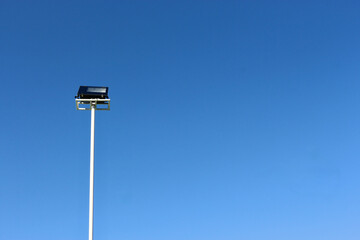 tall streetlight against clear blue sky, minimalistic and serene