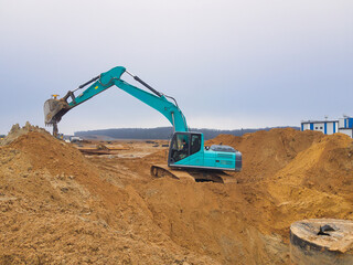 Excavator engages in earthmoving project amidst a cloudy sky at a construction site near the countryside