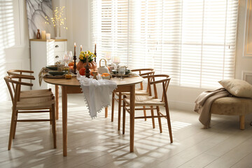 Stylish dining room with beautiful table setting and autumn decor