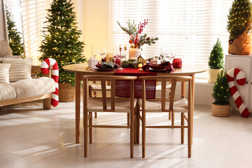 Christmas table setting with stylish dishware and festive decor indoors