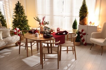 Christmas table setting with stylish dishware and festive decor indoors