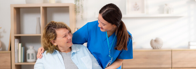 Caregiver asian woman care elderly sitting on wheelchair, consoling for encourage in living room at...