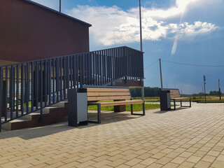 Modern benches enhance public space near a contemporary building under a bright sky