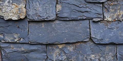 Slate fragments arranged on a textured gray rooftop background showcasing a grunge appearance with ample copy space for text integration.