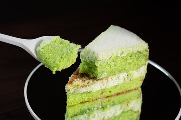 Vibrant Green Cake Slice on Reflective Surface