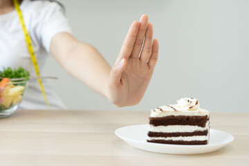 eat less sugar for health, women avoid to eat chocolate cake and sweets during sugar diet session...