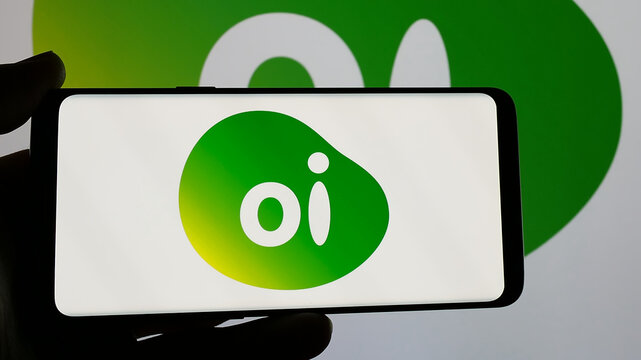 Stuttgart, Germany - 12-19-2024: Person holding smartphone with logo of Brazilian telecommunications company Oi SA on screen. Focus on phone display.