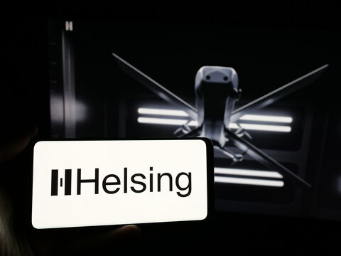 Stuttgart, Germany - 01-09-2025: Person holding smartphone with logo of German defense software company Helsing GmbH on screen in front of website. Focus on phone display.