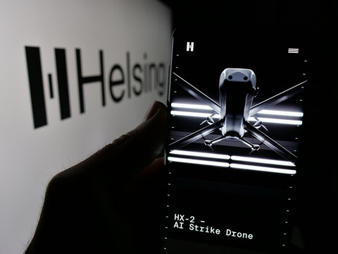 Stuttgart, Germany - 01-09-2025: Person holding mobile phone with website of German defense software company Helsing GmbH on screen with logo. Focus on center of phone display.