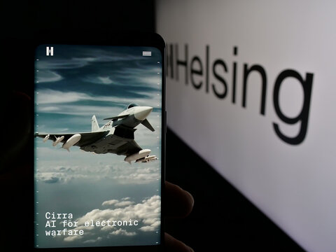 Stuttgart, Germany - 01-09-2025: Person holding cellphone with webpage of German defense software company Helsing GmbH on screen with logo. Focus on center of phone display.