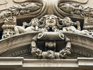 A large building features an artistic statue of a womans face on it