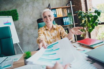 Photo of pretty retired female take graph documents colleague wear yellow print shirt formalwear coworking successful nice light office
