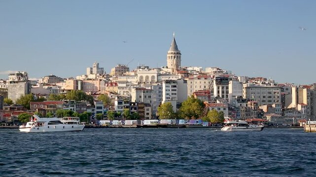 Galataport area, Beyoglu historic district and Galata tower medieval landmark, many flying seagulls with route ships and boats in Istanbul, Turkey. Summer sunny day