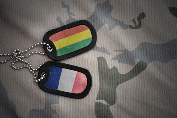 vintage army blank, dog tag with flag of bolivia and france on the khaki texture background....