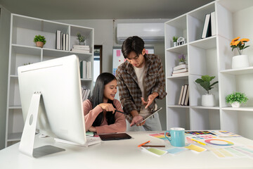 Creative design team collaborating at a modern workspace, discussing project ideas on a tablet