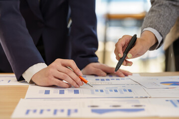 Close-up hand of businesswoman pointing at the graph in the meeting.