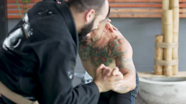 Two male athletes practicing jiu jitsu performing grappling movements and different holds