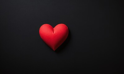 Obraz premium Bright red heart shaped object placed on a dark background, symbolizing love and affection. Valentine’s Day, date, engagement, love, wedding, background