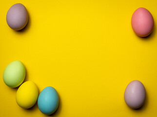 Happy easter decoration of colorful eggs on yellow background with space for text