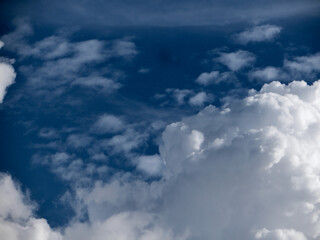 Fototapeta premium Towering Cotton-Like Clouds Against a Vivid Blue Sky – The Beauty of Nature’s Canvas