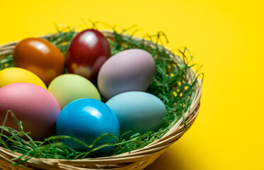 Easter eggs in a basket with yellow background
