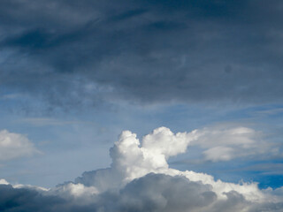 Obraz premium Dramatic Sky with Towering Cumulus Clouds Against a Deep Blue Backdrop – Nature’s Changing Moods