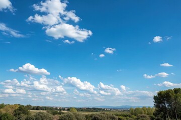 A serene landscape featuring a vibrant blue sky adorned with fluffy cumulus clouds, overlooking a tranquil countryside with lush green vegetation