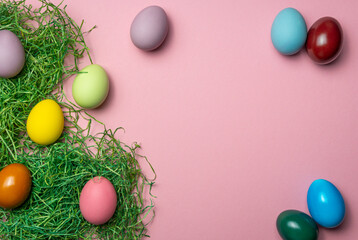 Easter eggs on grass decoration with pink background and space for text