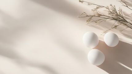 Three white eggs and delicate flowers on a clean white background with warm undertones creating a serene, minimalistic composition