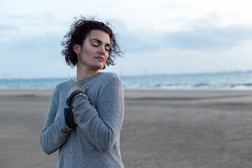 Portrait of a young woman with curly hair at sunset on the beach