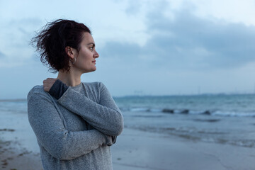 Portrait of a young woman with curly hair at sunset on the beach