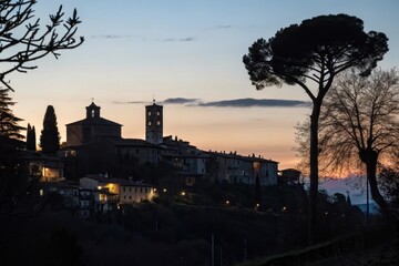 Sunset Silhouette of a Hilltop Village with Church and Tower