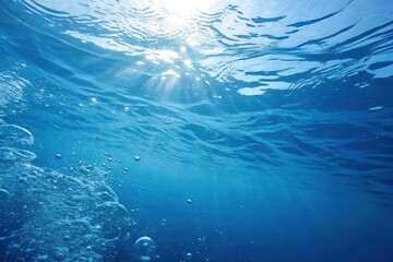 Obraz premium Underwater Scene Sunbeams Illuminate Deep Blue Water with Rising Bubbles