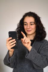 Fototapeta premium An isolated woman's portrait with a cell phone