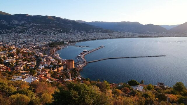 A panoramic view of the Red Tower ( Kizil Kule ) and Alanya harbour from Alanya castle. Sunrise time. mediterranean coast. Touristic beaches of Antalya. Turkey country - 4k video 