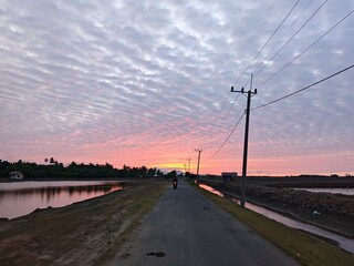 Dramatic Sunset Sky Over Rural Road and Ponds