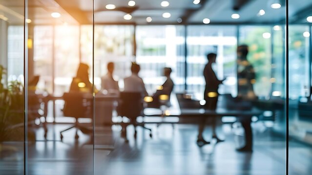 A blurred, interior business people at tables through a glass wall. This appears to be an office setting