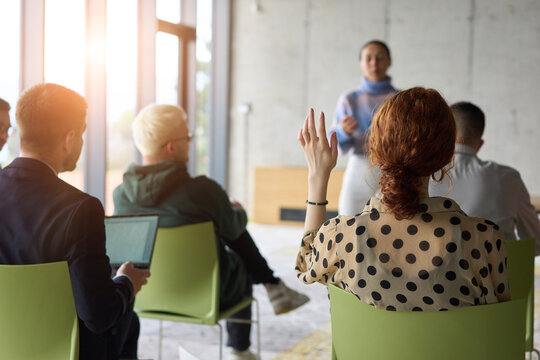 A diverse group of business professionals sits attentively in a modern office, actively participating in a training session led by an instructor, focusing on the latest technological advancements in