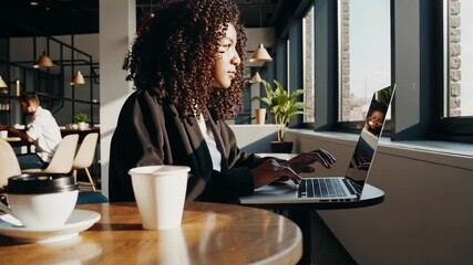 Woman with laptop in cozy cafe