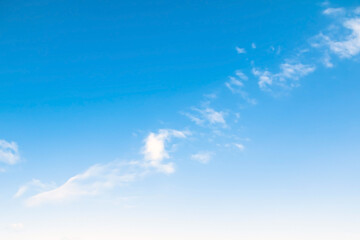 A vast expanse of blue sky. gradient from blue to white, separated by a strip of air clouds....